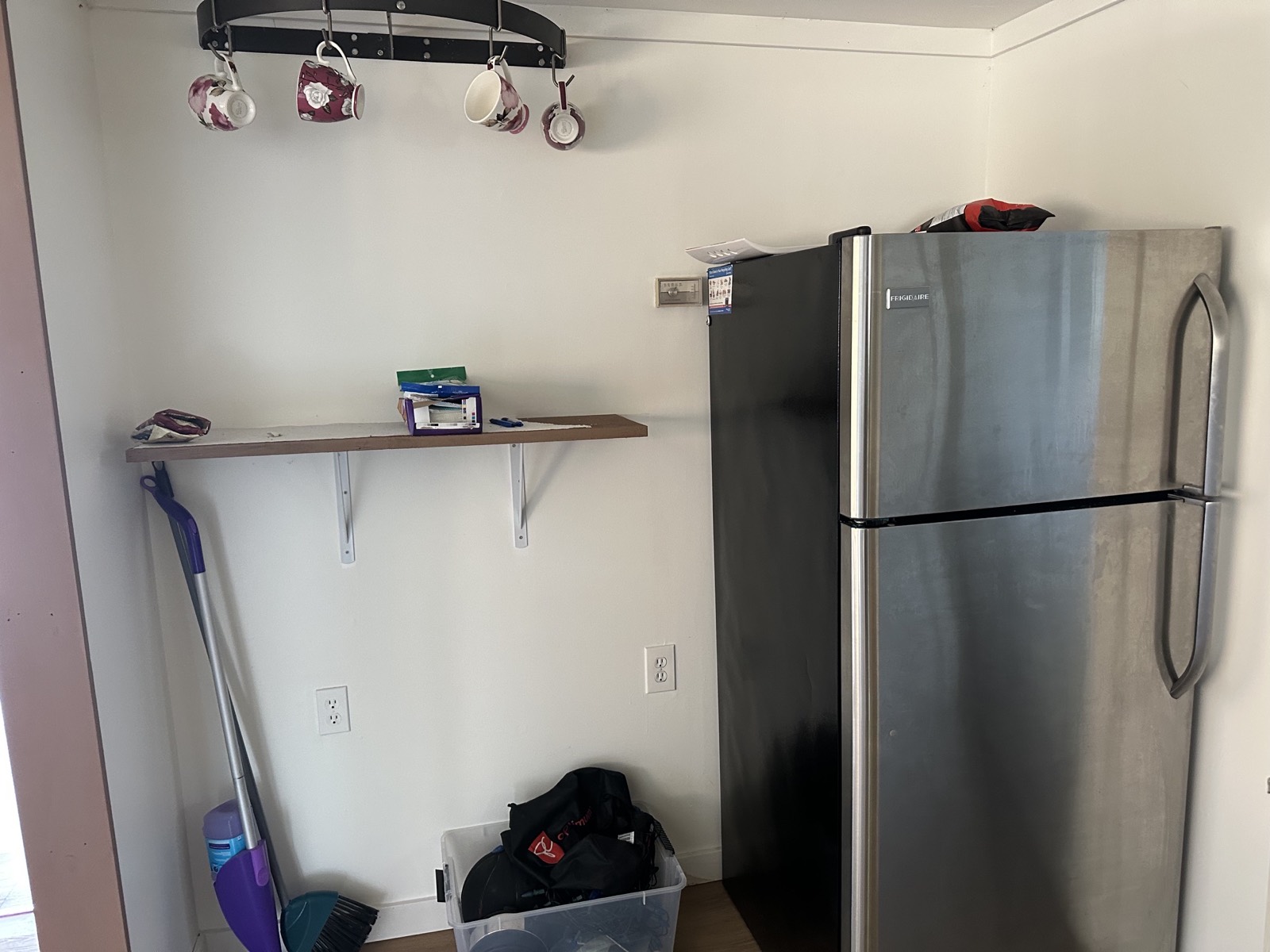 Fridge against a bare wall with hooks
