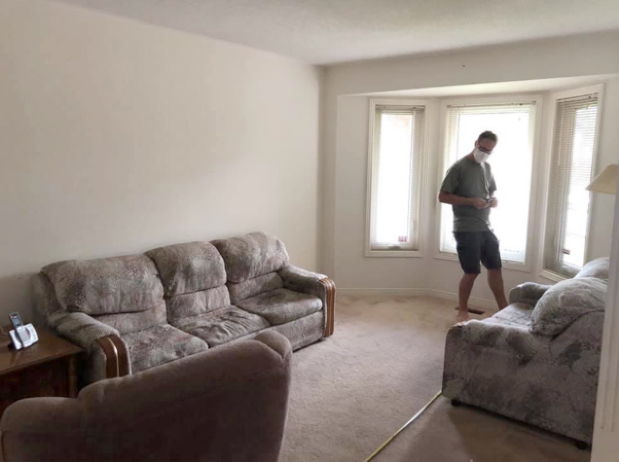 Living room before: broadloom carpet and worn sofas