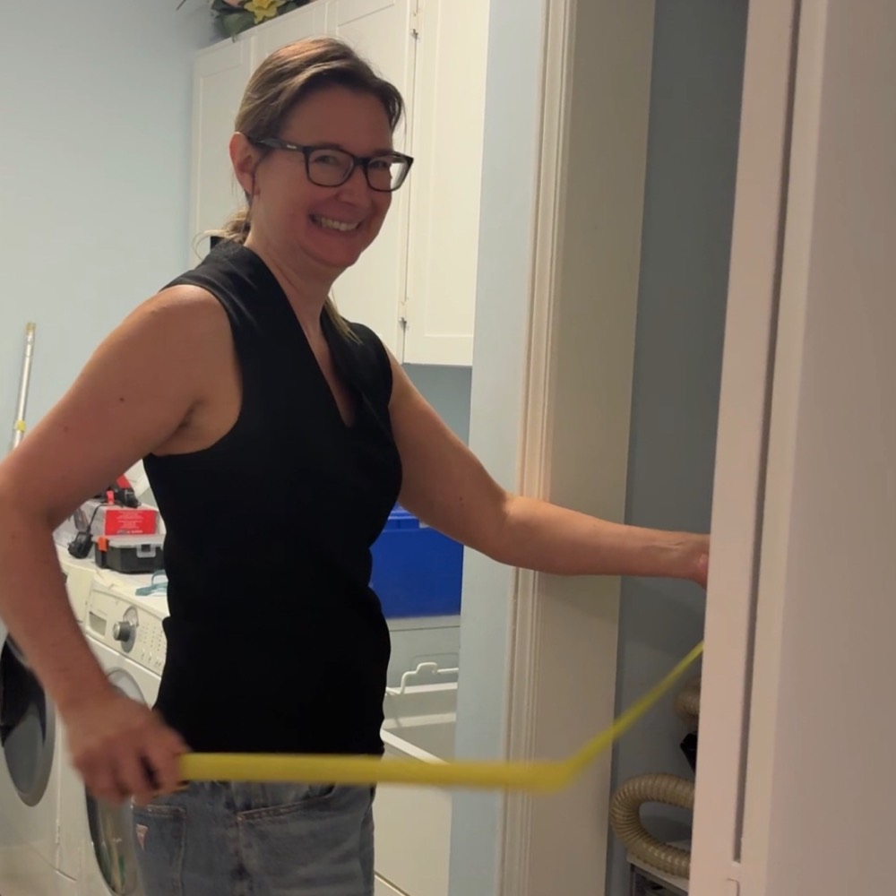 Dianna at a doorway with a level in hand