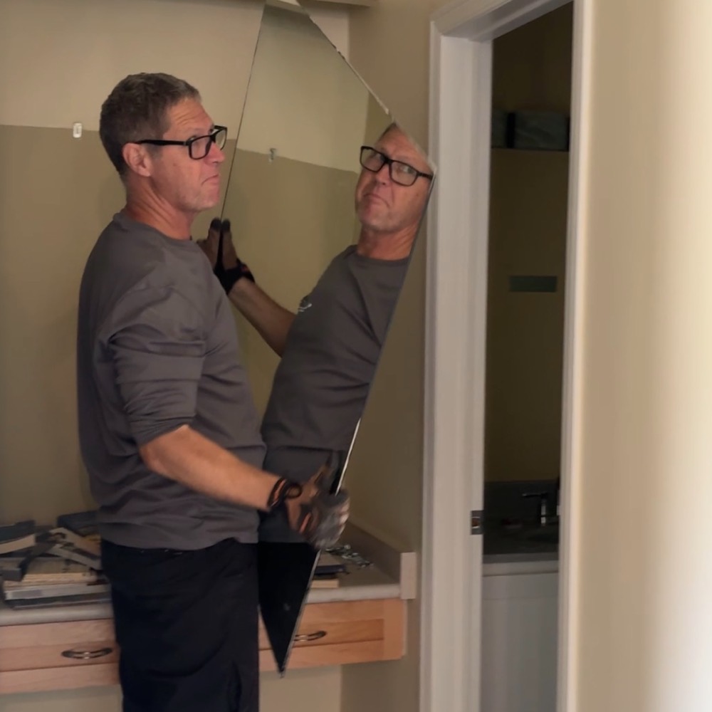 Michael lifting a mirror into place