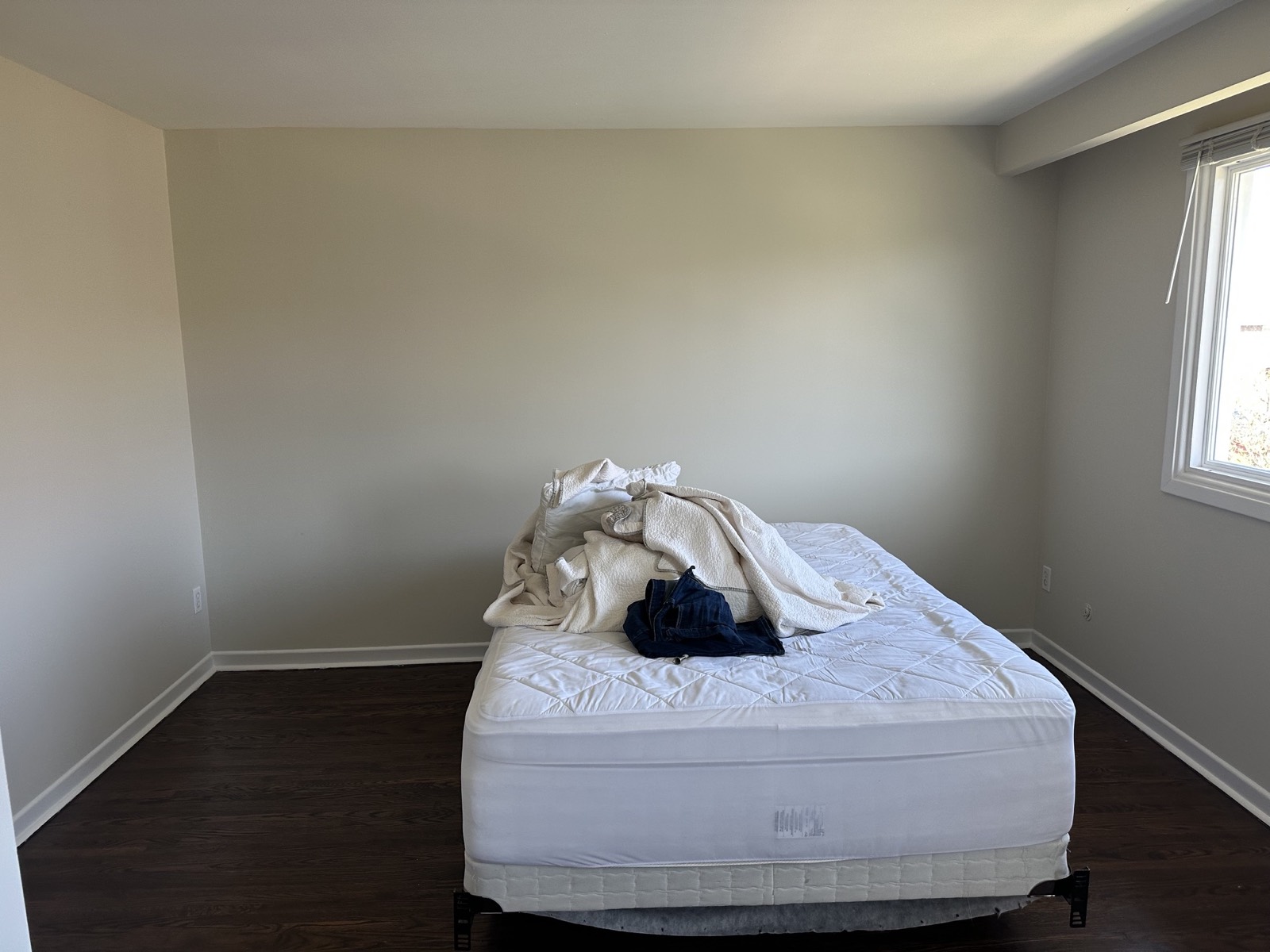 Bedroom before, a bare mattress under the window